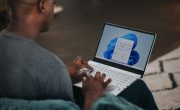 man in gray long sleeve shirt using Windows 11 computer