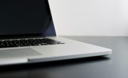 silver laptop computer on black table