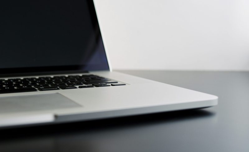 silver laptop computer on black table