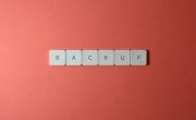 Free Close-up of keyboard keys spelling 'BACKUP' placed on a coral-colored surface. Stock Photo