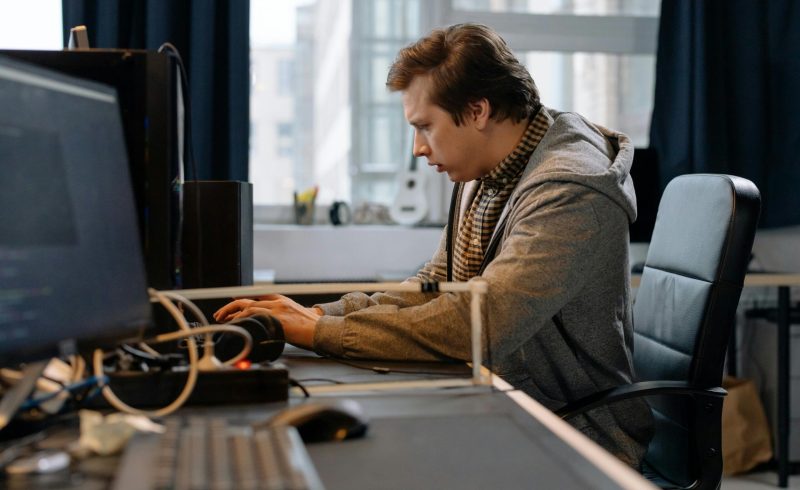 Free A concentrated professional working at a computer in a modern office setting. Stock Photo