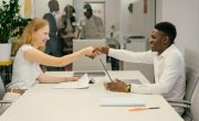Free Business professionals completing a successful deal with a handshake in a modern office setting. Stock Photo