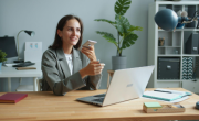 lady holding phone while working on a laptop