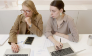 two women with laptops
